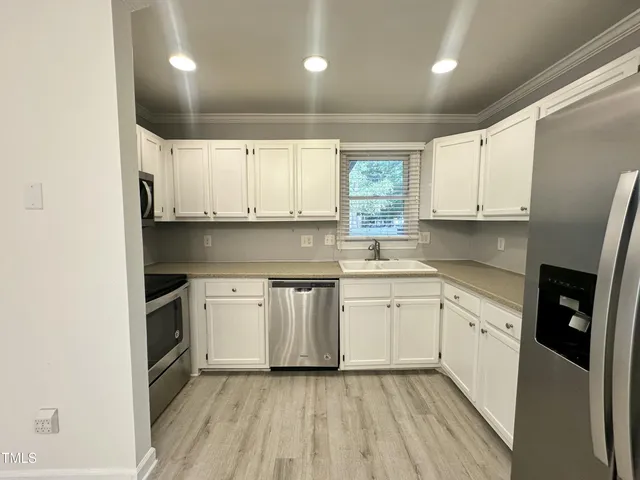 a kitchen with granite countertop white cabinets and white appliances