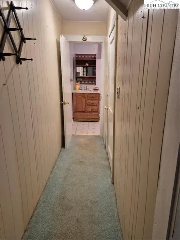 a view of a hallway to a room with wooden floor and staircase