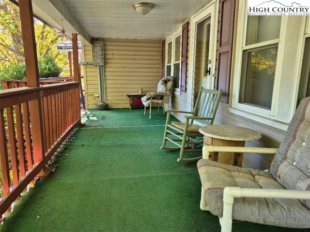 a porch with chairs and a yard