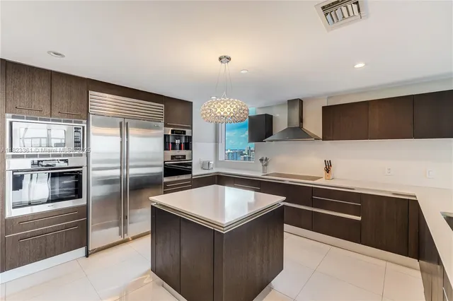 a kitchen with granite countertop a sink dishwasher a refrigerator and a stove