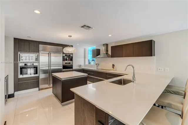 a kitchen with stainless steel appliances granite countertop a sink a stove and a refrigerator