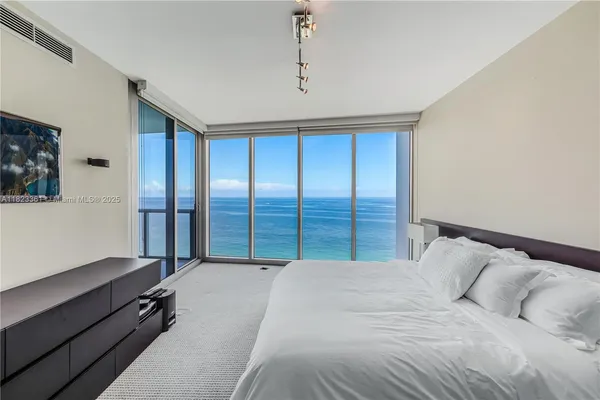 a bedroom with a large bed and a large window