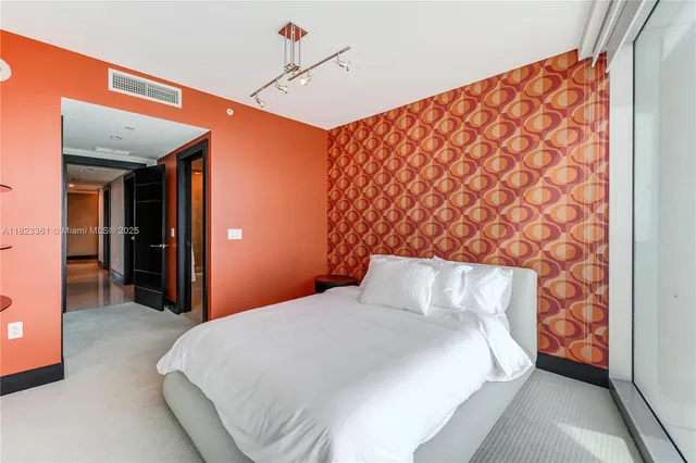 a bedroom with a bed and a lamp next to a window