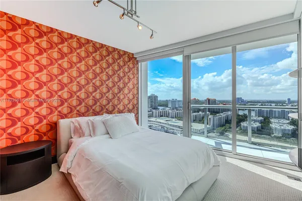 a bedroom with a large bed and a lamp next to a window