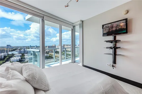 a bedroom with furniture and a flat screen tv