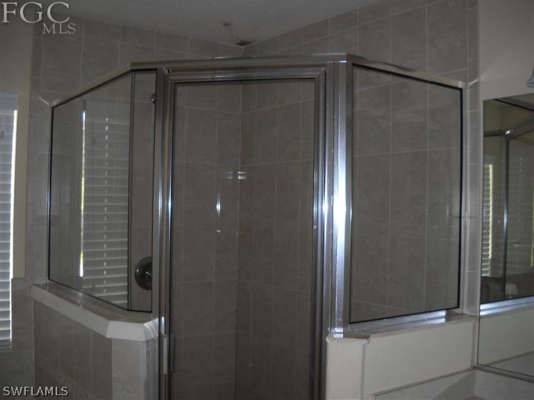 6973 Debrita Road North Port, FL 34291 - Photo 13 of 18 a bathroom with a glass shower door