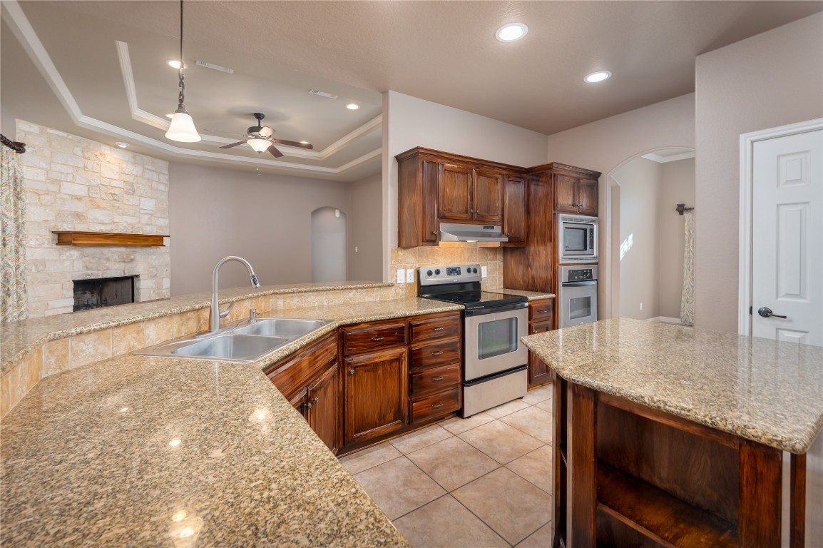 455 Rose Blossom Loop La Vernia, TX 78121 - Photo 7 of 24 a large kitchen with granite countertop a large counter top space appliances and cabinets