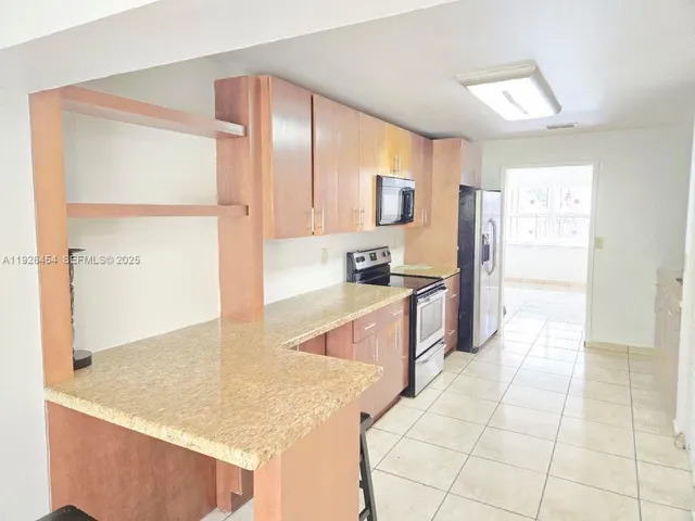 a large kitchen with kitchen island a sink a counter top and cabinets