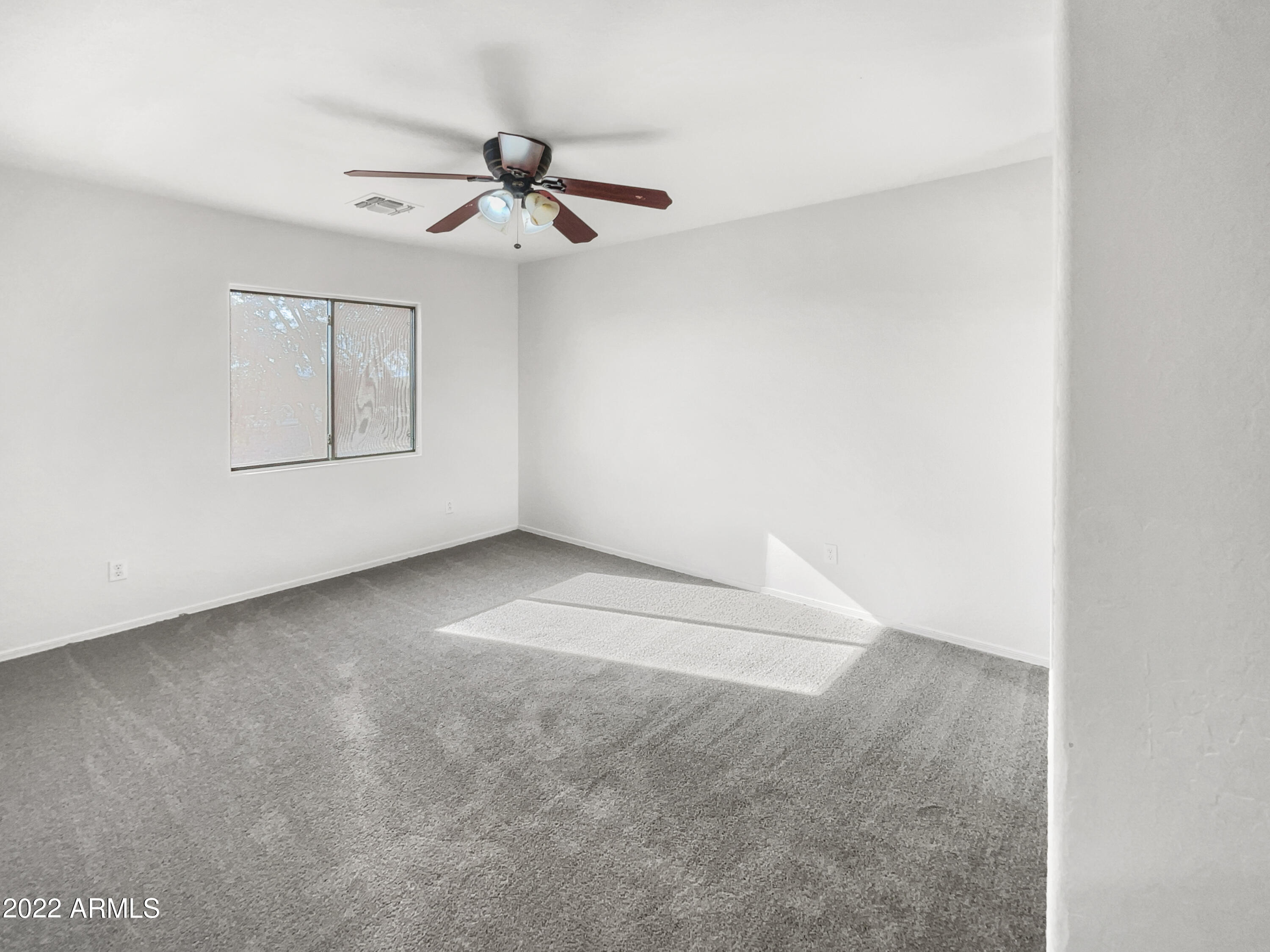 44011 West Cowpath Road Maricopa, AZ 85138 - Photo 11 of 18 an empty room with a ceiling fan and windows