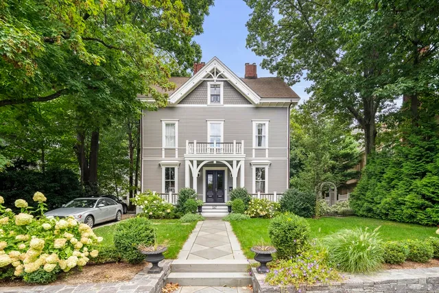 a front view of a house with a yard and potted plants
