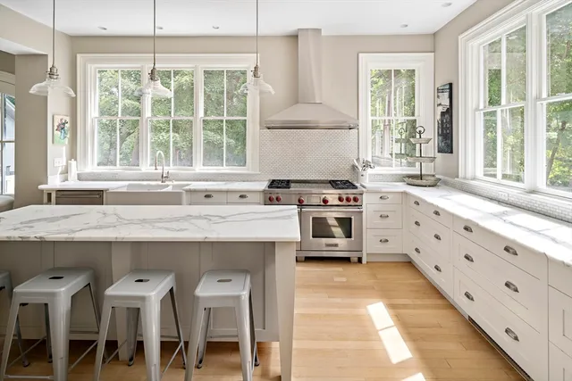 a kitchen with granite countertop a stove a sink and a refrigerator