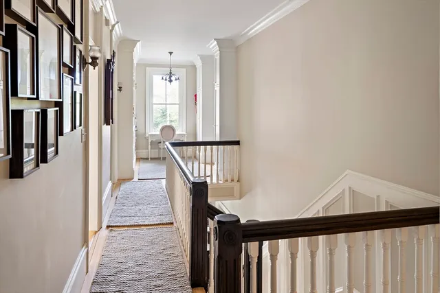 a view of a hallway with wooden floor and staircase