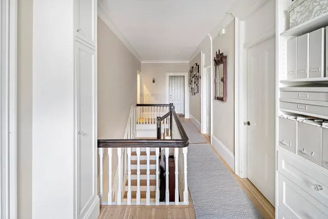 a view of a hallway with wooden floor and entryway
