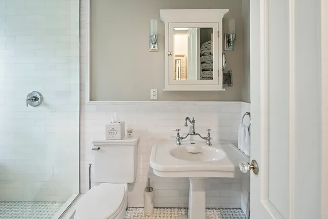 a bathroom with a sink a toilet and shower