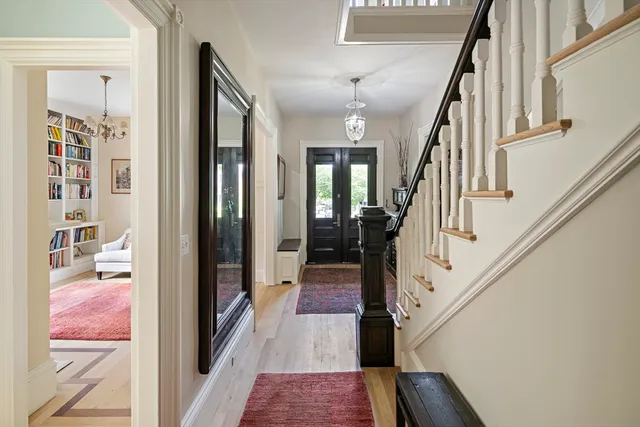 a view of a hallway with wooden floor and staircase
