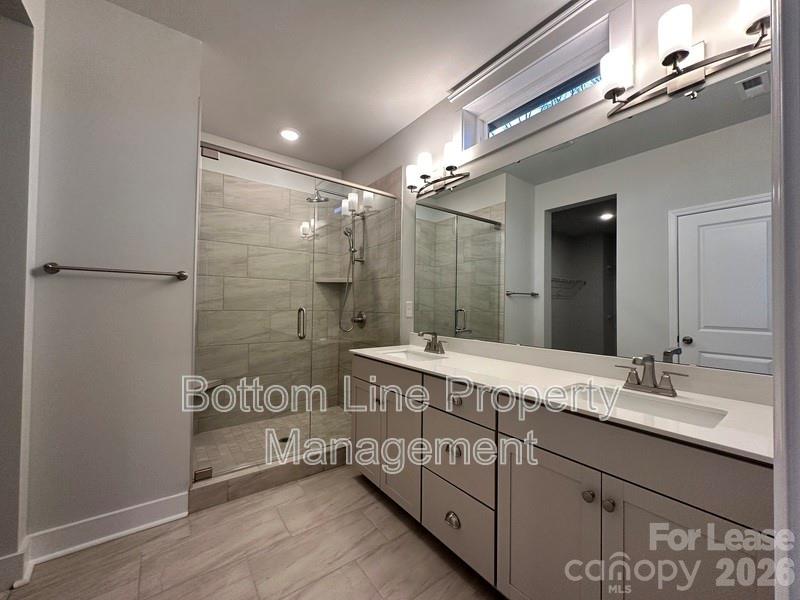 5915 Ardrey Kell Road Charlotte, NC 28105 - Photo 12 of 19 a spacious bathroom with a shower sink and mirror