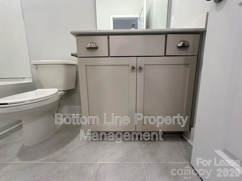 5915 Ardrey Kell Road Charlotte, NC 28105 - Photo 16 of 19 a bathroom with a toilet a sink and mirror