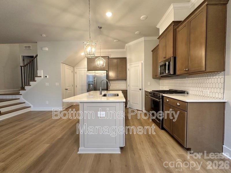 5915 Ardrey Kell Road Charlotte, NC 28105 - Photo 4 of 19 a kitchen with stainless steel appliances granite countertop a sink a stove and a wooden floors