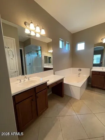a spacious bathroom with a double vanity sink mirror and bathtub