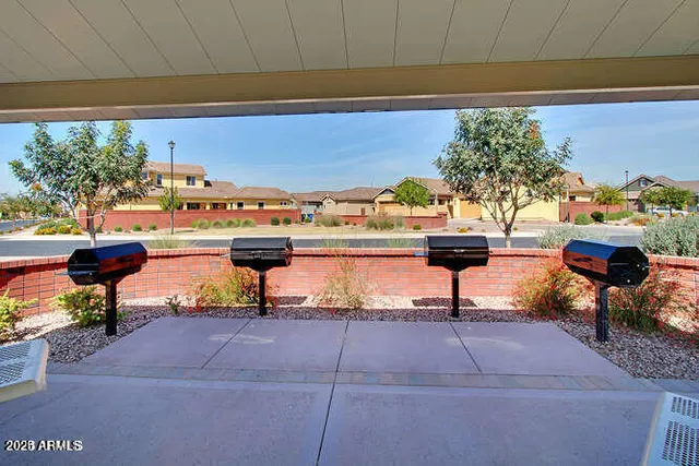 a view of a patio with a table and chairs under an umbrella