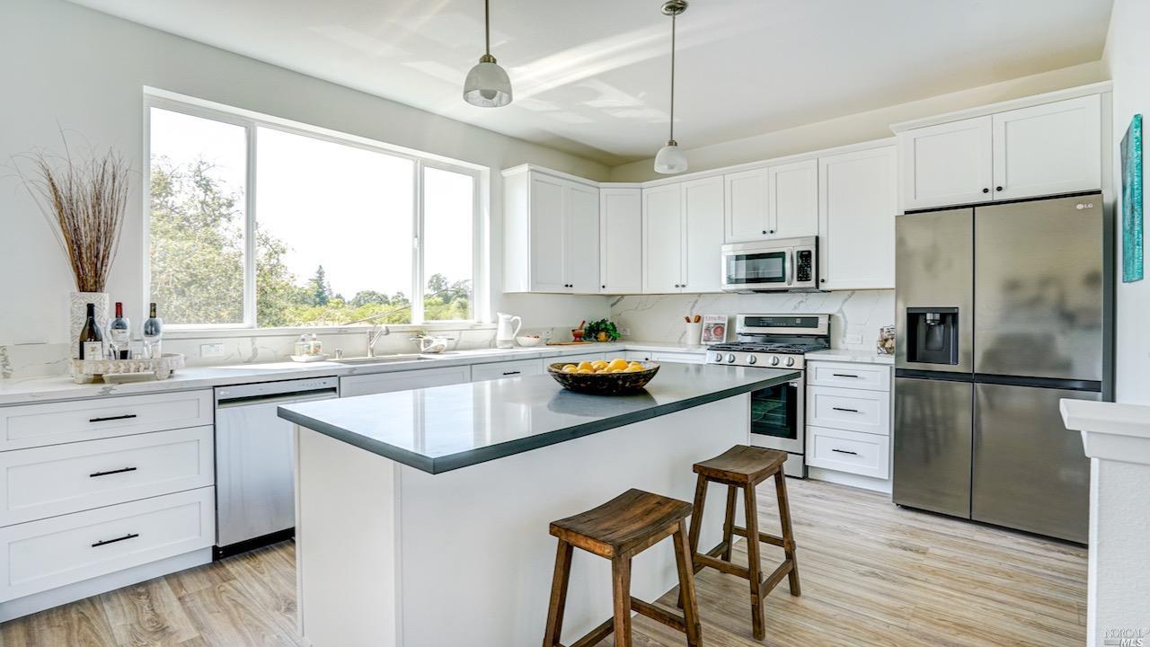 a kitchen with stainless steel appliances a stove a sink refrigerator and microwave