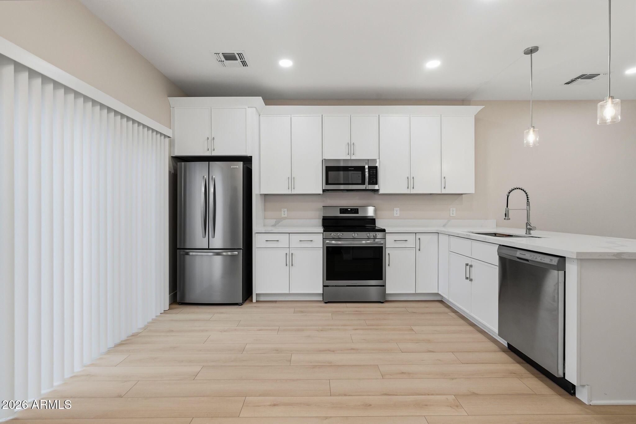 1222 East Diamond Street, Unit 2 Phoenix, AZ 85006 - Photo 12 of 35 a kitchen with cabinets stainless steel appliances and wooden floor