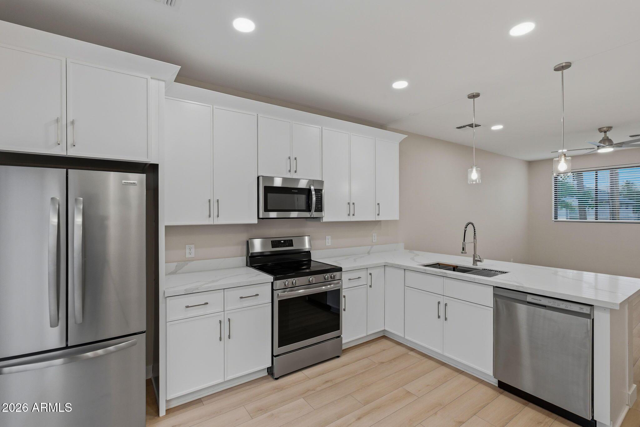 1222 East Diamond Street, Unit 2 Phoenix, AZ 85006 - Photo 14 of 35 a kitchen with a sink white cabinets and stainless steel appliances