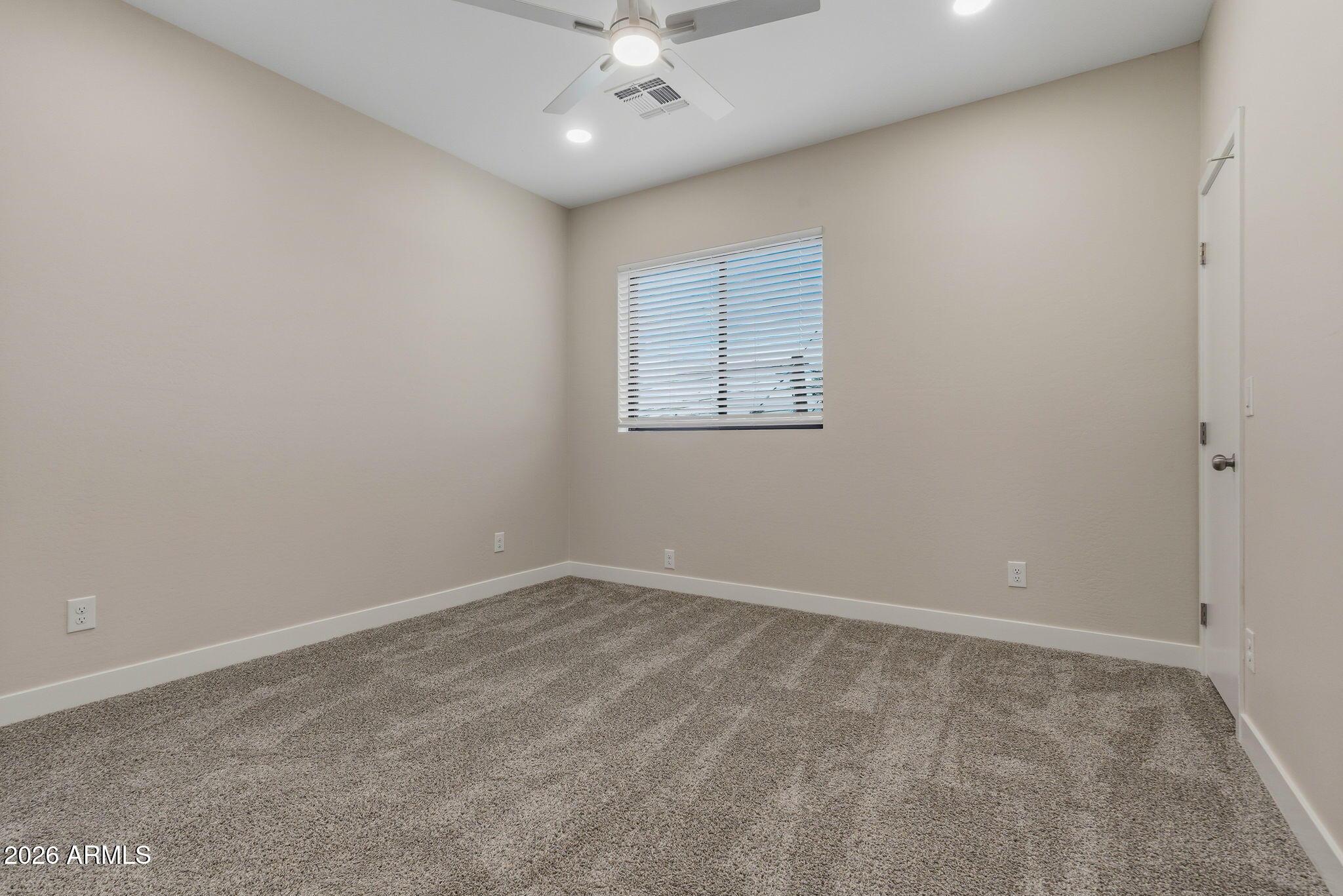 1222 East Diamond Street, Unit 2 Phoenix, AZ 85006 - Photo 21 of 35 an empty room with a ceiling fan and a window