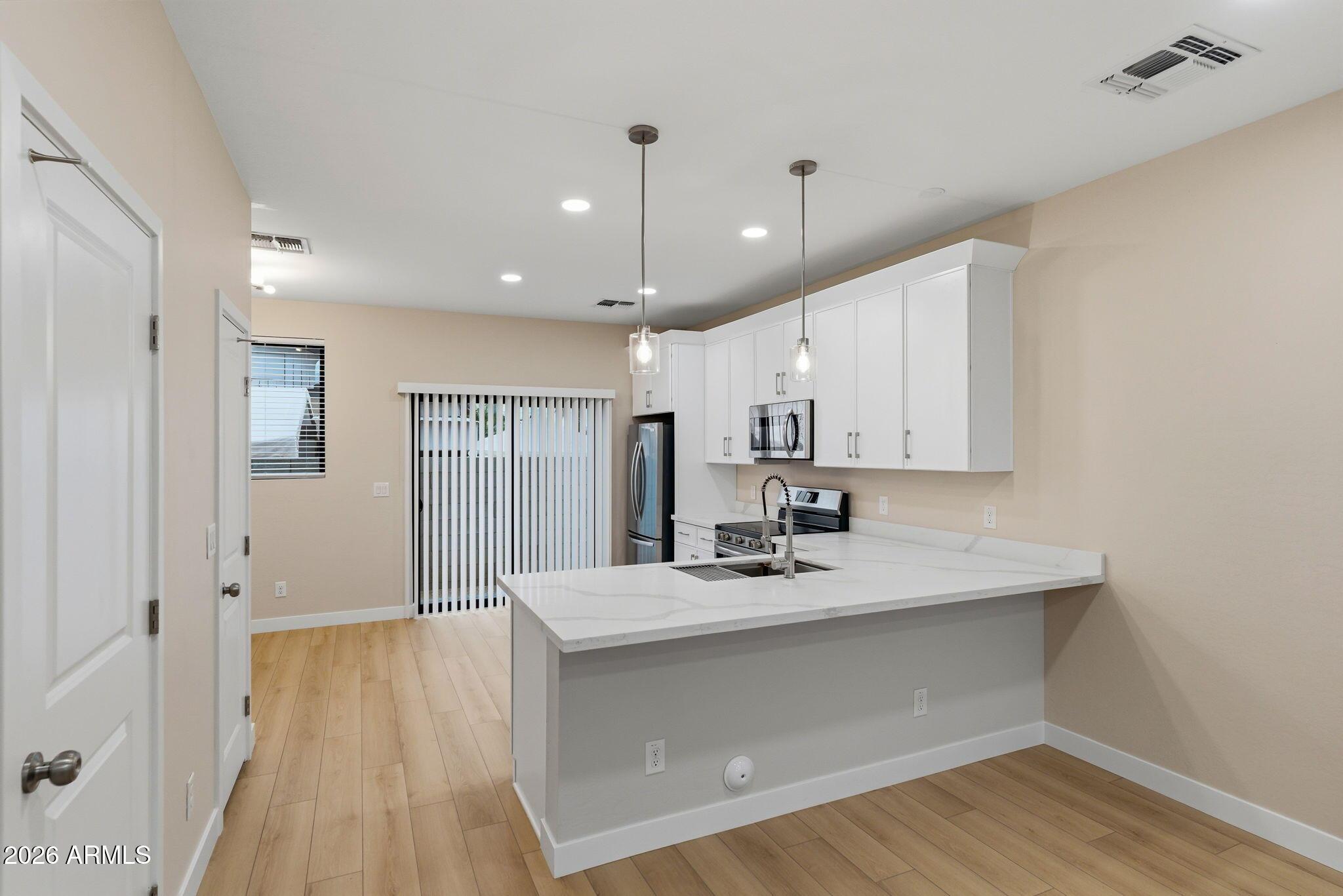 1222 East Diamond Street, Unit 2 Phoenix, AZ 85006 - Photo 9 of 35 a view of a kitchen with kitchen island a sink wooden floor and a refrigerator