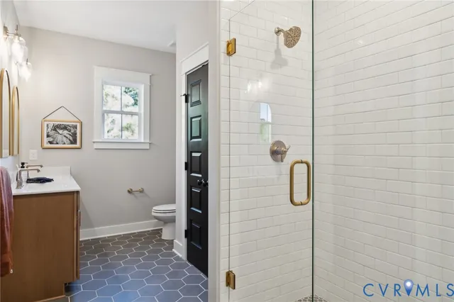 a bathroom with a granite countertop shower a toilet and a sink