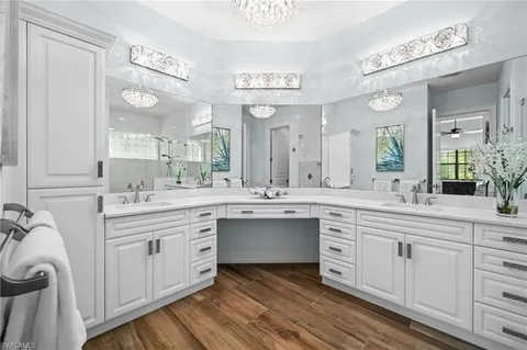 a spacious bathroom with a double vanity sink a mirror and a shower