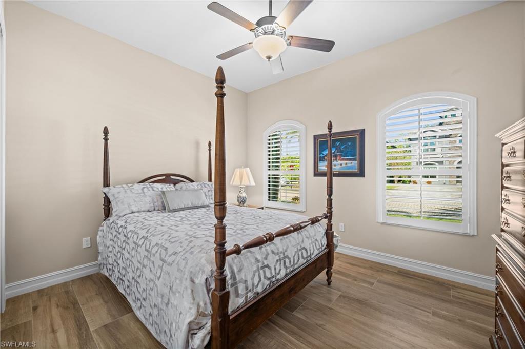 14686 Reserve Place Naples, FL 34109 - Photo 24 of 49 a bedroom with a bed chandelier and a window