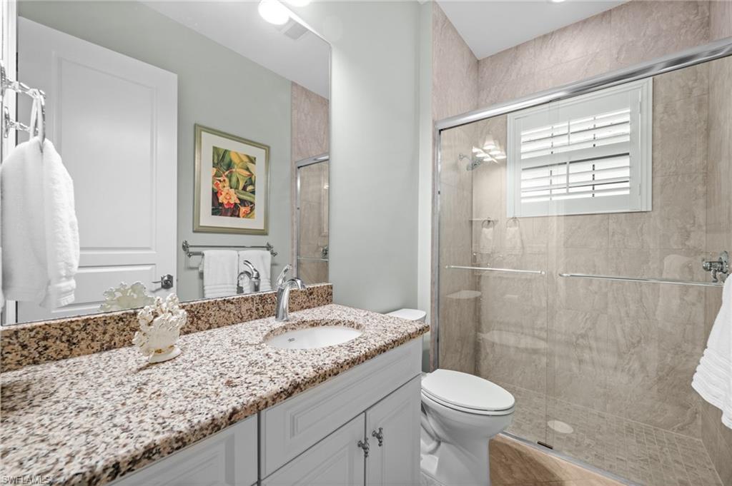 14686 Reserve Place Naples, FL 34109 - Photo 26 of 49 a bathroom with a granite countertop sink toilet and a mirror