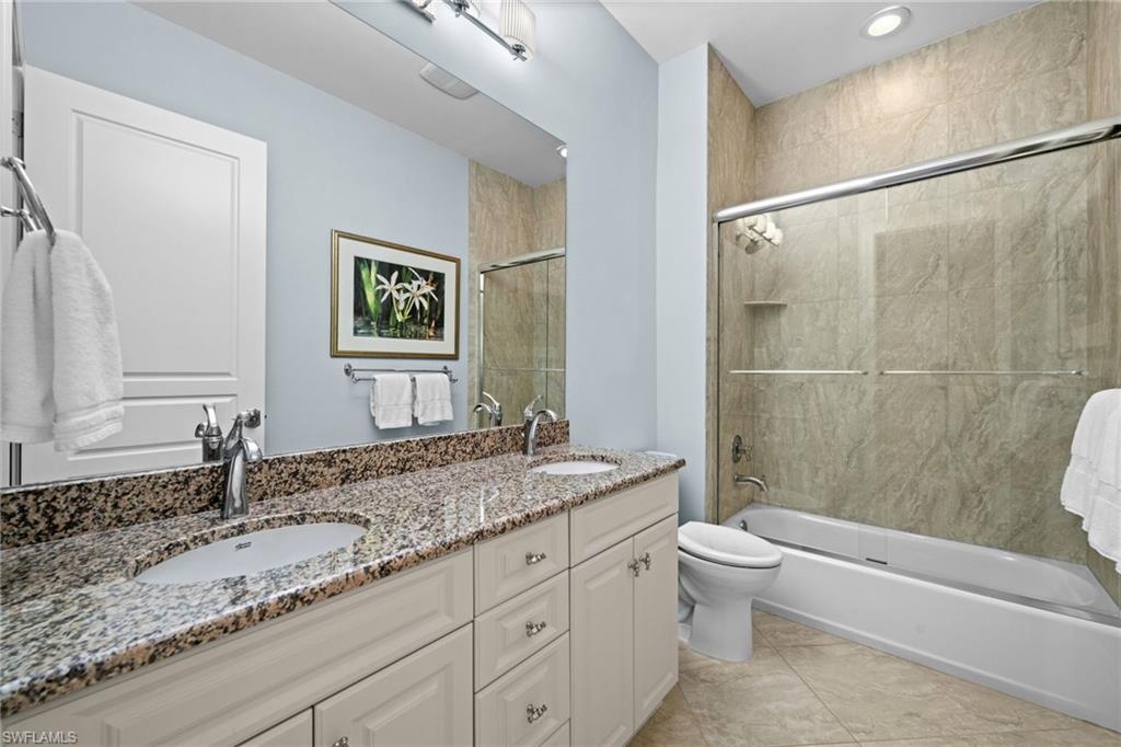 14686 Reserve Place Naples, FL 34109 - Photo 29 of 49 a bathroom with a granite countertop sink toilet and shower