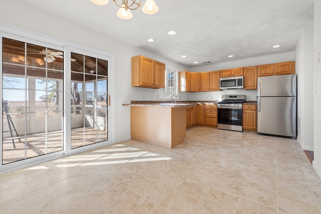 188 Beach Road, Unit 15 Salisbury, MA 01952 - Photo 6 of 39 a kitchen with stainless steel appliances granite countertop a stove top oven a sink and a refrigerator