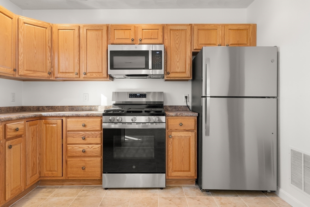 188 Beach Road, Unit 15 Salisbury, MA 01952 - Photo 7 of 39 a white refrigerator freezer and a stove sitting inside of a kitchen