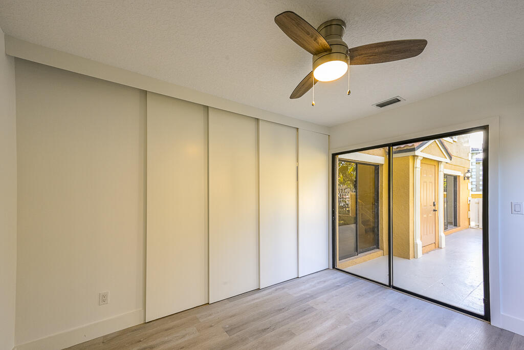 356 Prestwick Circle, Unit 3 Palm Beach Gardens, FL 33418 - Photo 19 of 42 a view of an empty room with wooden floor and a window