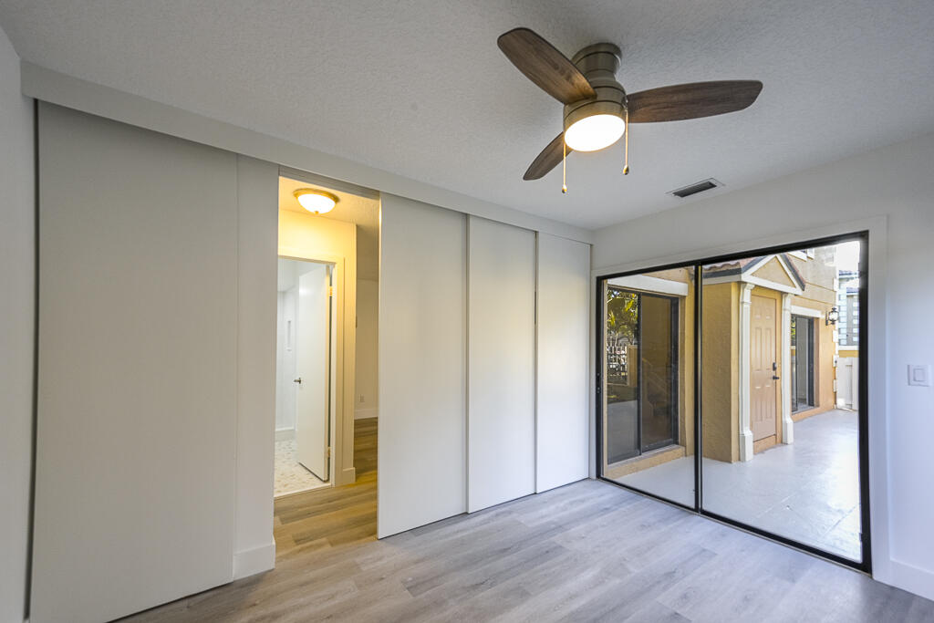 356 Prestwick Circle, Unit 3 Palm Beach Gardens, FL 33418 - Photo 20 of 42 a view of an empty room with wooden floor and a window