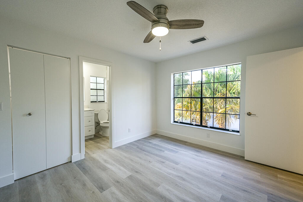 356 Prestwick Circle, Unit 3 Palm Beach Gardens, FL 33418 - Photo 22 of 42 a view of an empty room with a window and wooden floor