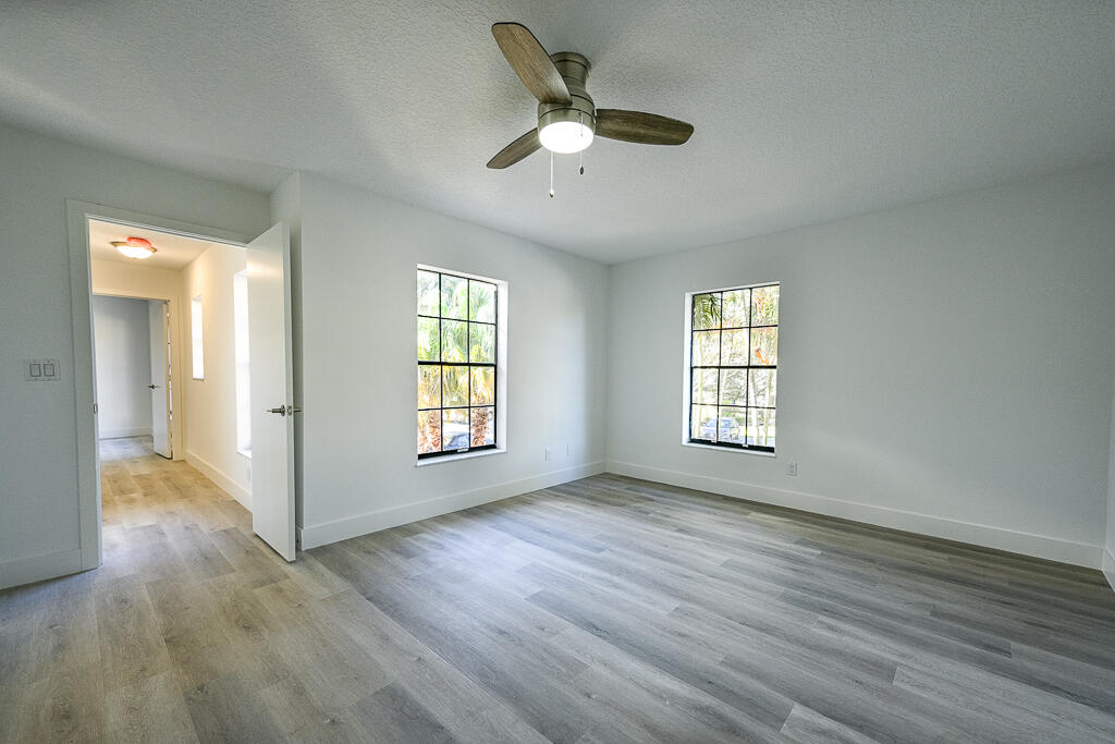356 Prestwick Circle, Unit 3 Palm Beach Gardens, FL 33418 - Photo 23 of 42 a view of an empty room with wooden floor and a window