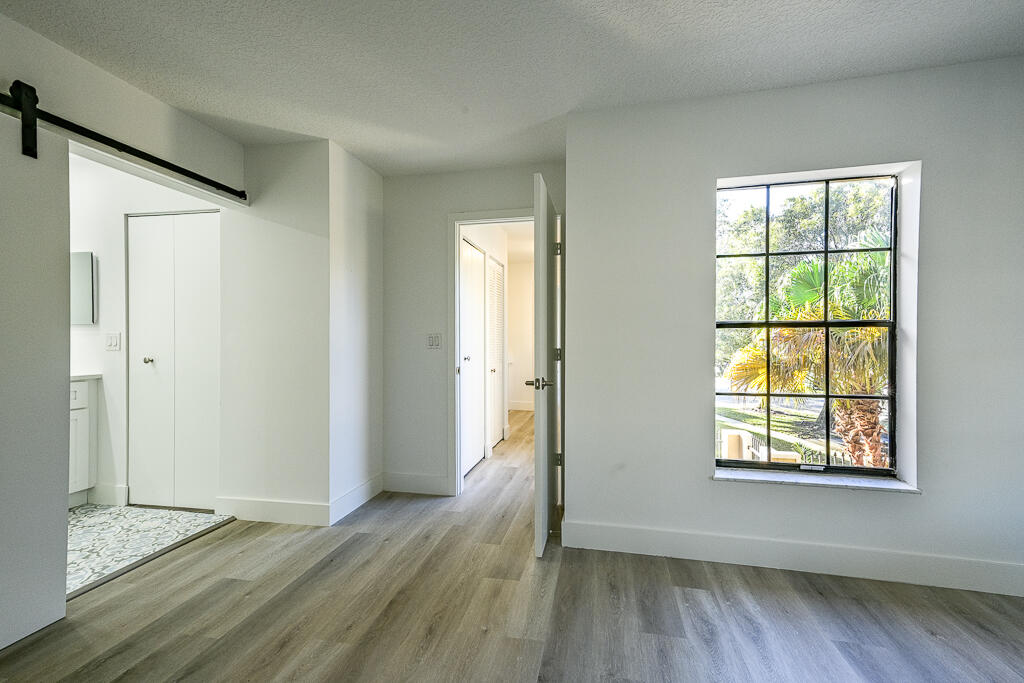 356 Prestwick Circle, Unit 3 Palm Beach Gardens, FL 33418 - Photo 24 of 42 an empty room with wooden floor and windows