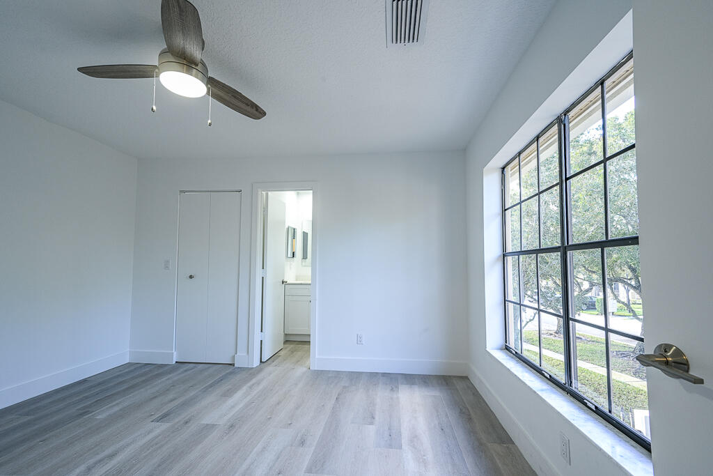 356 Prestwick Circle, Unit 3 Palm Beach Gardens, FL 33418 - Photo 28 of 42 wooden floor in an empty room with a window