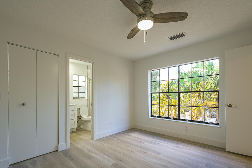 356 Prestwick Circle, Unit 3 Palm Beach Gardens, FL 33418 - Photo 29 of 42 a view of an empty room with a window and wooden floor