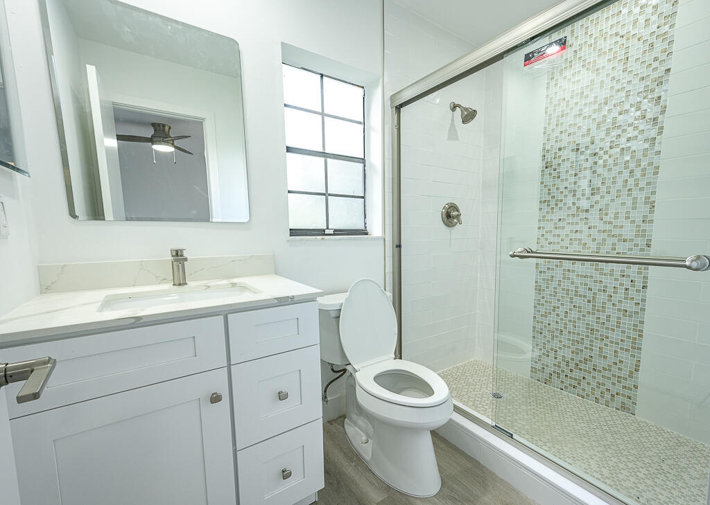 356 Prestwick Circle, Unit 3 Palm Beach Gardens, FL 33418 - Photo 30 of 42 a bathroom with a shower a sink a toilet and shower