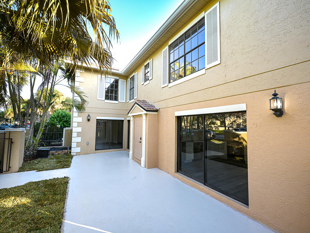 356 Prestwick Circle, Unit 3 Palm Beach Gardens, FL 33418 - Photo 3 of 42 a view of a house with a yard and garage