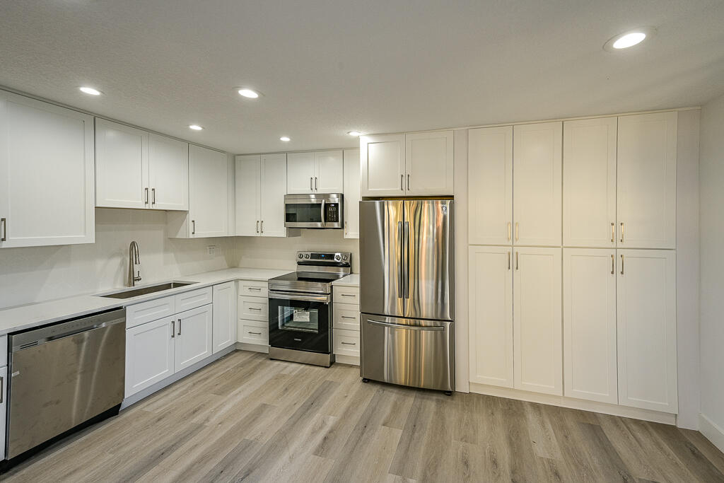 356 Prestwick Circle, Unit 3 Palm Beach Gardens, FL 33418 - Photo 5 of 42 a kitchen with granite countertop appliances a sink and a refrigerator