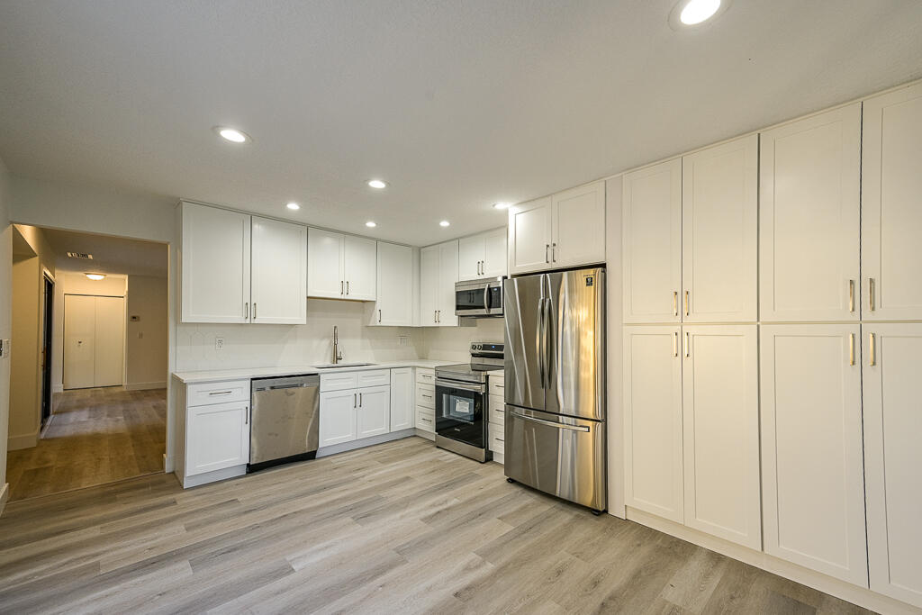 356 Prestwick Circle, Unit 3 Palm Beach Gardens, FL 33418 - Photo 6 of 42 a kitchen with stainless steel appliances granite countertop a refrigerator and a stove top oven