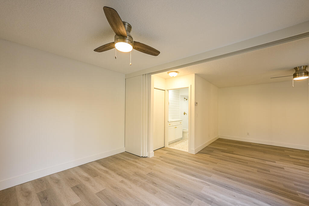 356 Prestwick Circle, Unit 3 Palm Beach Gardens, FL 33418 - Photo 9 of 42 an empty room with wooden floor cabinet and ceiling fan