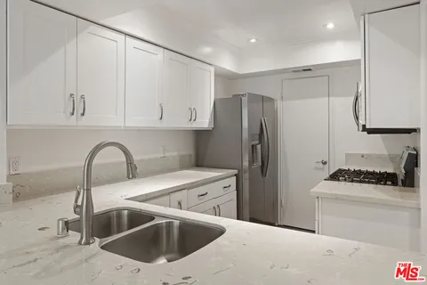 a kitchen with a sink cabinets and stainless steel appliances
