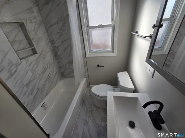 a bathroom with a tub sink and toilet